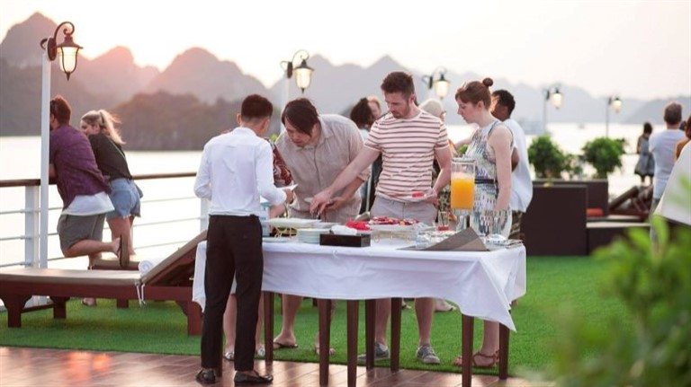 Du khách tham gia buổi tiệc hoàng hôn trên du thuyền Mon Cheri với đồ ăn, thức uống đa dạng. 