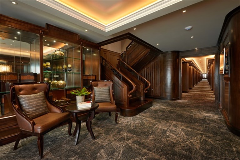 Khu vực lễ tân nổi bật với hành lang trải dài và nội thất gỗ nâu trầm vô cùng sang trọng.