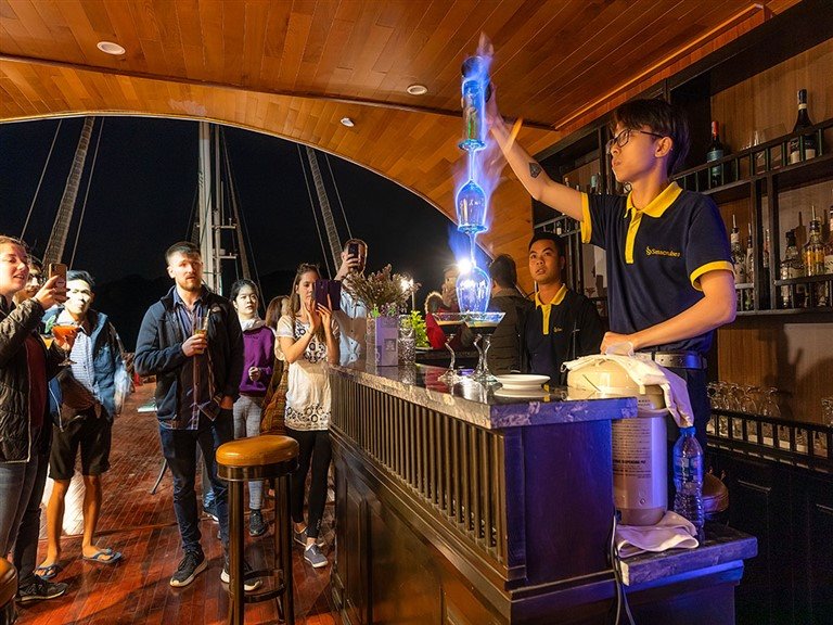 Du khách thích thú với những màn pha chế độc đáo tại quầy bar của du thuyền. 