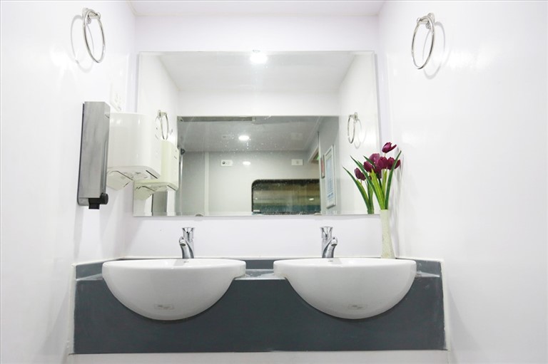 Bồn rửa tay sang trọng, hiện đại, được lắp gương lớn và hoa tươi thơm ngát giúp hạn chế các mùi hơi khó chịu.