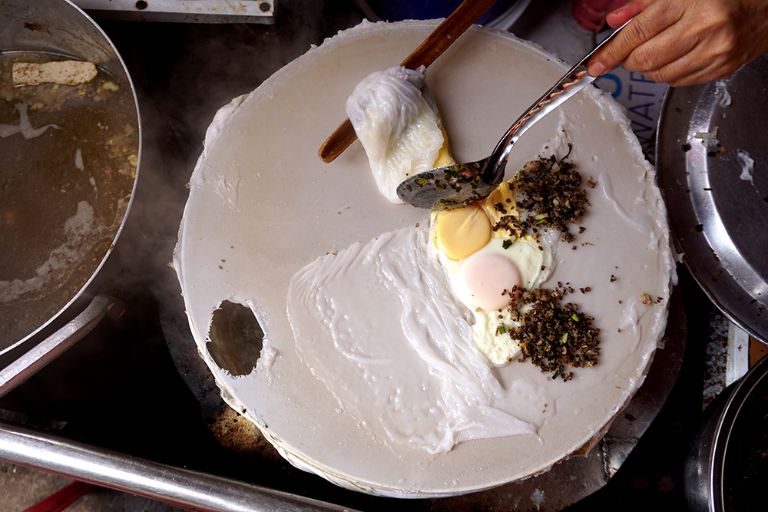 Sau khi bột và nước được trộn đều và bánh cuốn đã được trải đều trên màn hấp, người làm bánh sẽ thêm 2 quả trứng vào và nhanh chóng đậy kín để bánh được hấp chín