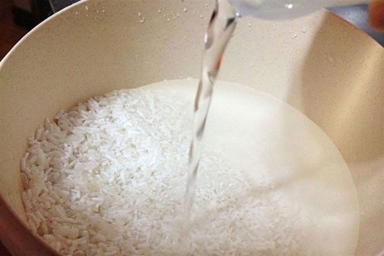 Ngâm gạo nếp Yên Minh qua đêm để gạo thêm trắng, mềm và dẻo thơm hơn.