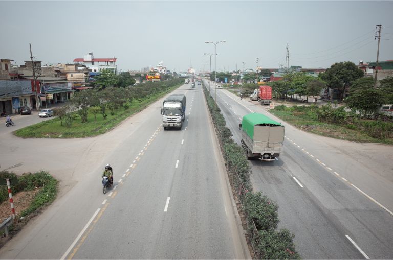 Hành khách thưởng ngoạn cảnh quê hương qua khung cửa sổ trên xe.