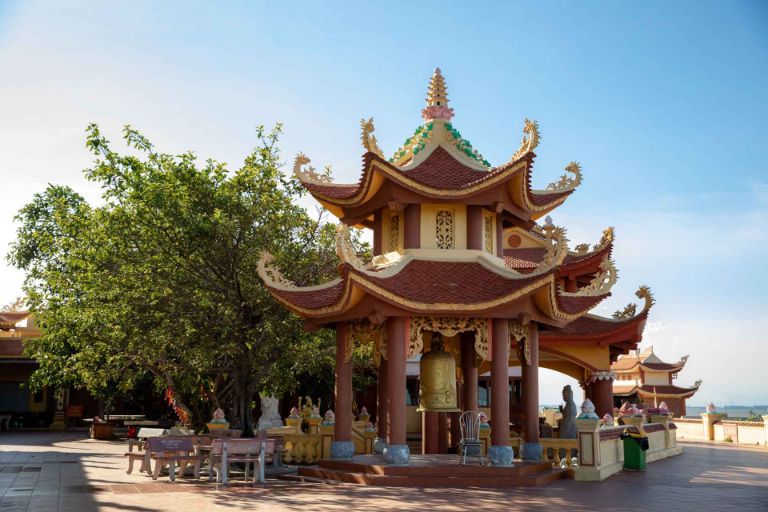 Lối bậc đá dẫn lên đền ẩn mình dưới tán cây, tạo cảm giác thanh tịnh và linh thiêng.